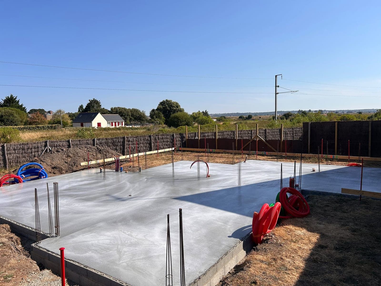 Dalle béton coulée sur un soubassement en parpaing, attentes d'acier en place