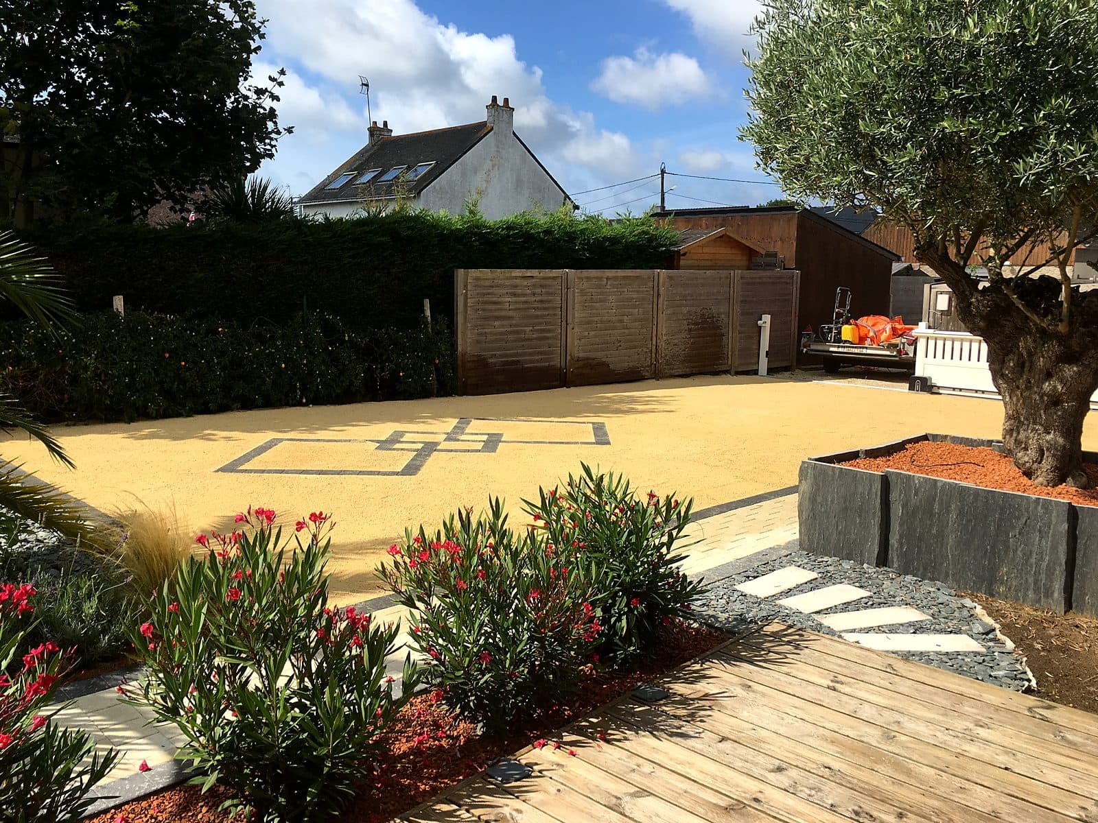 Cour en gravier stabilisé, calepinage en pavés et lauriers roses en fleurs