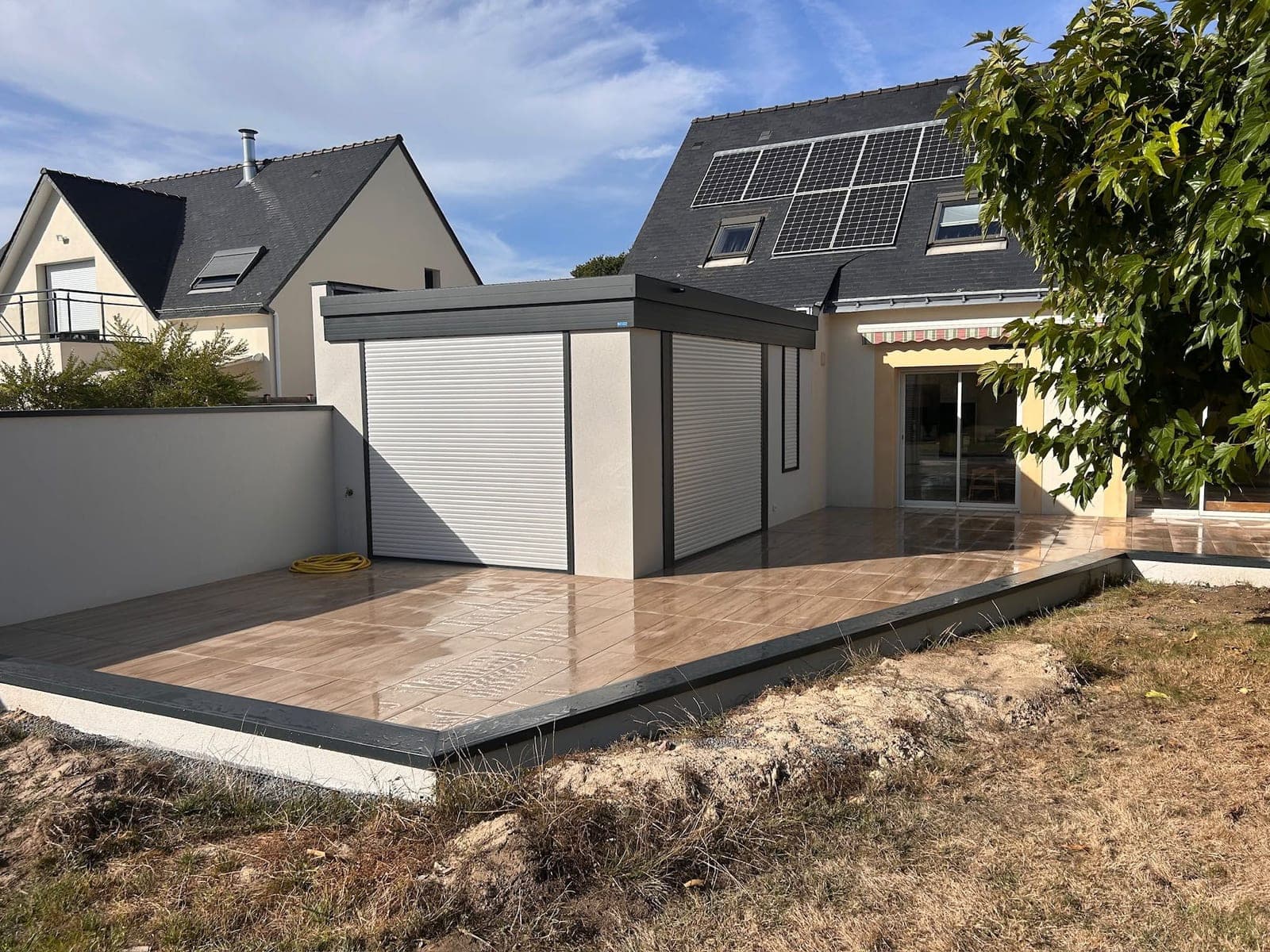 Terrasse en carrelage effet bois posée sur plots, rive en aluminium gris